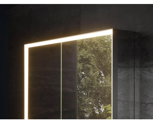 Zrcadlová skříňka s osvětlením na tmavé zdi