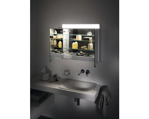 Moderní koupelna se zrcadlovou skříňkou, umyvadlem a doplňky.