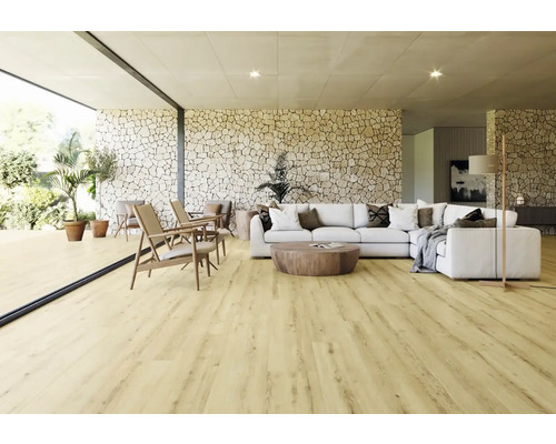 Světlý obývací pokoj s laminátovou podlahou, pohovkou, křesly a kamennou zdí