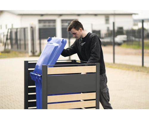 Kontejnerový box s osobou, která do něj vkládá modrý kontejner na odpad