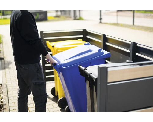 Osoba tlačí modrý odpadkový koš do boxu na popelnice