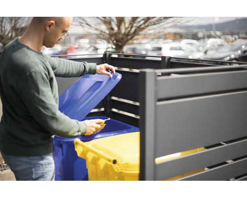 Muž otevírá skříň na popelnice se dvěma popelnicemi