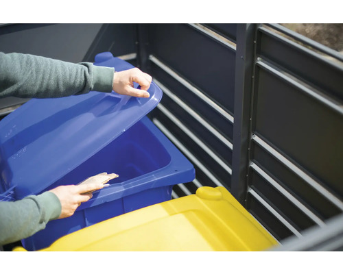 Osoba otevírá víko modrého odpadkového koše v úložném boxu na popelnice.