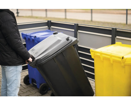 "Osoba tlačí popelnici s kolečky