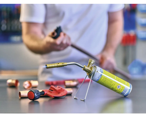 Pájecí lampa, měděné trubky a řezačka trubek na pracovní desce