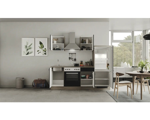 Kompletní kuchyňská linka s dřezem, sporákem, troubou, digestoří, horními skříňkami a lednicí ve světlé kuchyni.