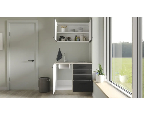 Světlá místnost s kuchyňským koutem, horní skříňkou a oknem