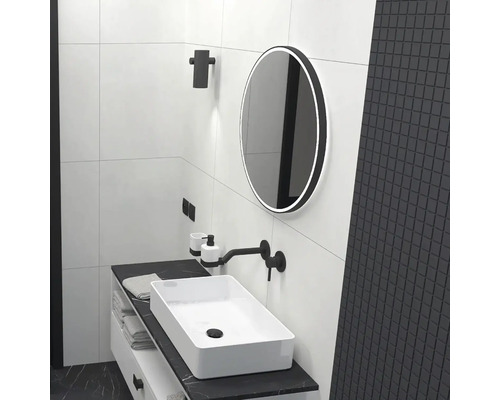 Světlá koupelna s umyvadlem, zrcadlem a černými akcenty pro elegantní design.