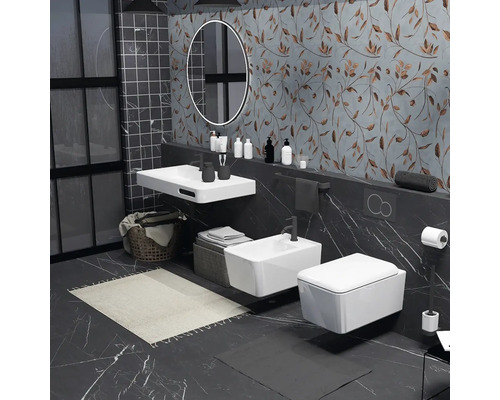 Moderní koupelna s umyvadlem, bidetem a toaletou zavěšenými na stěně před vzorovanou stěnou