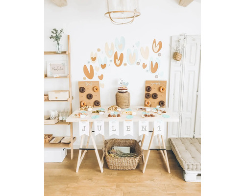 Ozdobený narozeninový stůl s koblihami, dortem a občerstvením na oslavu