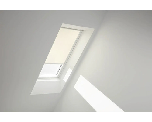 Střešní okno s roletou v světlé místnosti.