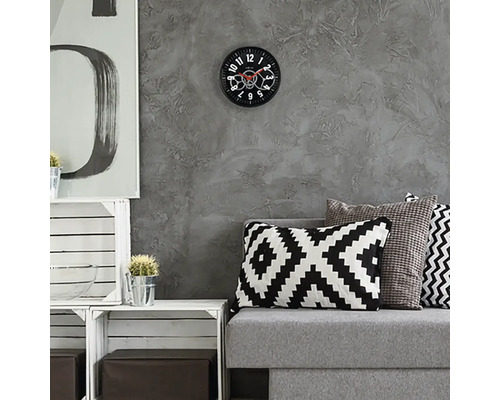 Obývací pokoj s šedou pohovkou, polštáři a nástěnnými hodinami s viditelným mechanismem