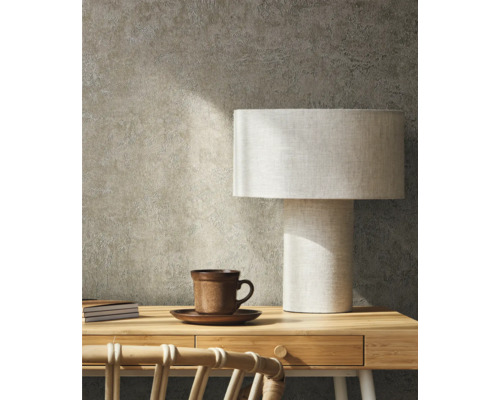 Scéna s psacím stolem, stolní lampou, šálkem a zápisníky na pozadí texturované stěny