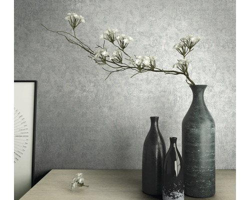 Dekorativní zátiší s vázami a umělými květinami na stole.