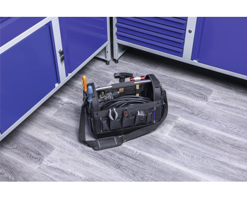 Plná brašna na nářadí s různým nářadím a modrými skříněmi na nářadí