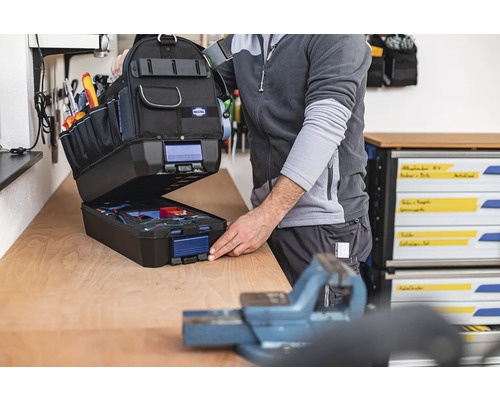 Otevřená brašna na nářadí s nářadím na pracovním stole