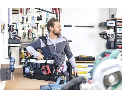 Řemeslník s brašnou na nářadí v dílně