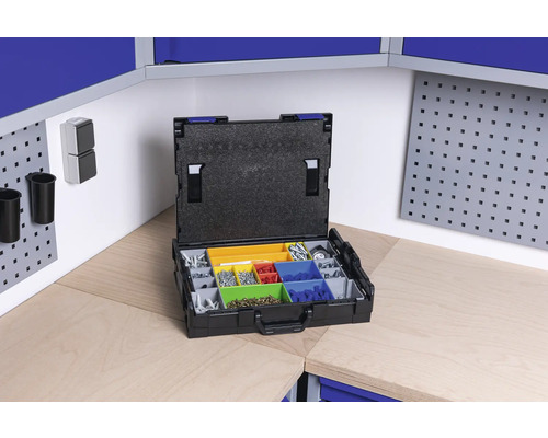 Otevřený sortimentní box s různými šrouby a drobnými díly na pracovním stole