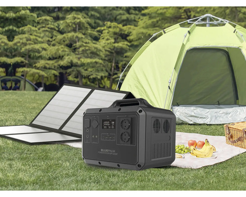 Přenosná napájecí stanice Bluepalm se solárním modulem před stanem na louce