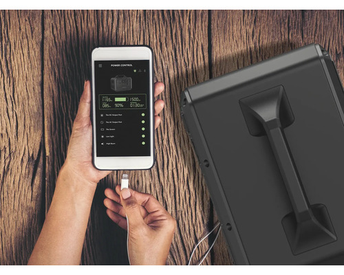 Osoba ovládá napájecí stanici pomocí aplikace pro smartphone.