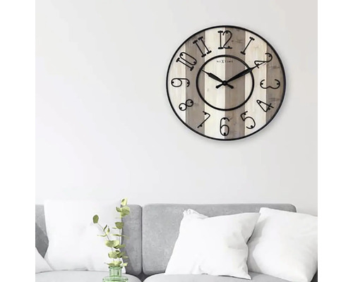 Nástěnné hodiny Nextime s číslicemi na světlém dřevěném pozadí