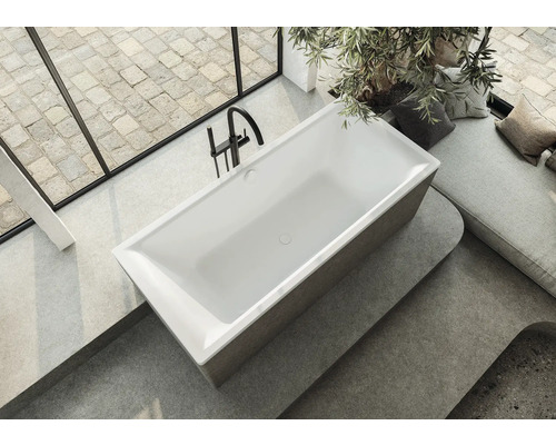 Volně stojící vana v světlé koupelně s oknem