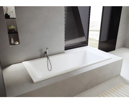 Vestavěná obdélníková vana s ruční sprchou ve světlé koupelně.