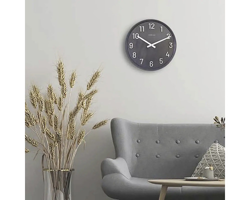 Obývací pokoj s šedou pohovkou, stolem, dekorací a kulatými nástěnnými hodinami