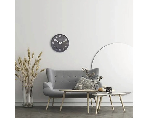 Obývací pokoj s šedou pohovkou, konferenčními stolky, nástěnnými hodinami a dekorací