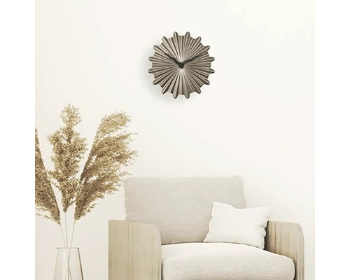 Dekorativní nástěnné hodiny nad křeslem v obývacím pokoji.