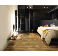 Ložnice s dřevěnou podlahou, postelí a černými skleněnými dveřmi