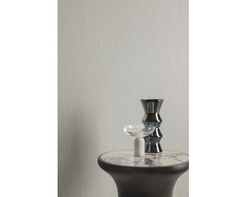 Světlá vliesová tapeta s textilní strukturou a stůl s dekorací