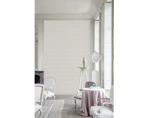 Světlá místnost v klasickém stylu s tapetou se vzorem, židlemi a dekoracemi.