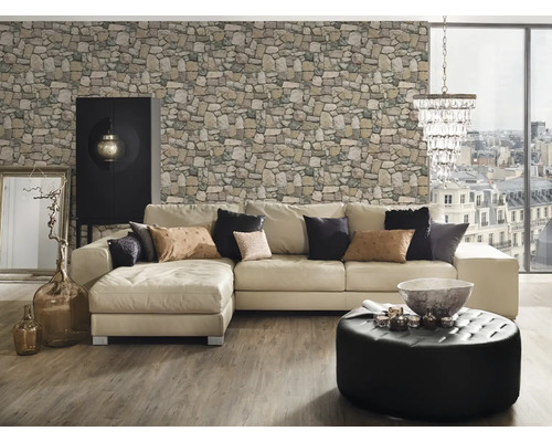 Obývací pokoj s rohovou pohovkou, kamennou tapetou, otomanským taburetem, skříní a dekoracemi.