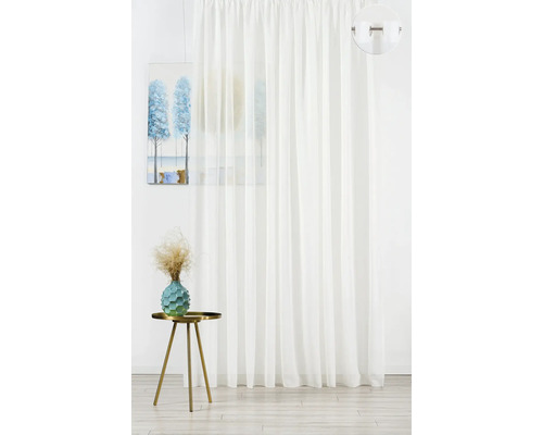 Bílý panelový závěs vedle stolu s dekorací a obrazem.