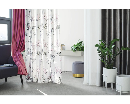 Obývací pokoj se závěsy z různých materiálů a vzorů, doplněný rostlinami a posezením