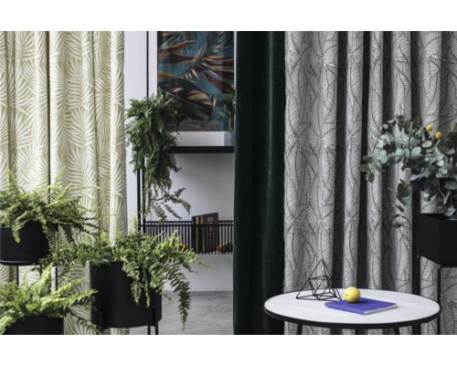 Pohled do pokoje se závěsy s listovým vzorem, pokojovými rostlinami a příručním stolkem