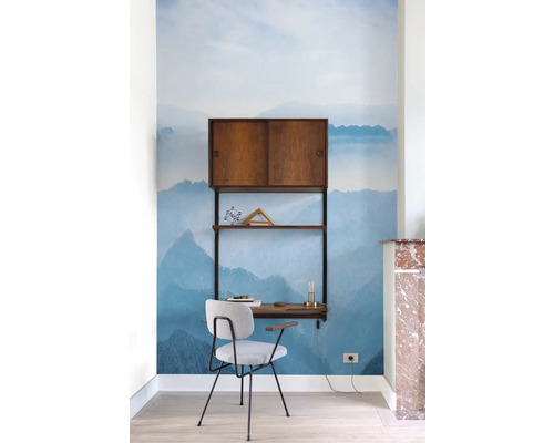 Pracovna se stolem, židlí a policí před fototapetou s motivem hory