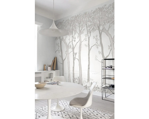 Světlá místnost s tapetou se stromovým motivem, jídelní stůl a židle