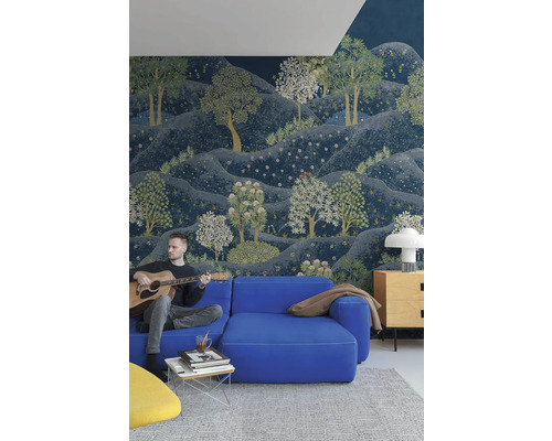 Obývací pokoj s modrou pohovkou, konferenčním stolkem a nástěnnou tapetou s motivem lesa