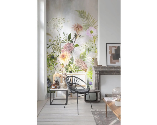 Obývací pokoj s květinovou tapetou, ratanovým křeslem, odkládacím stolkem a dekorací