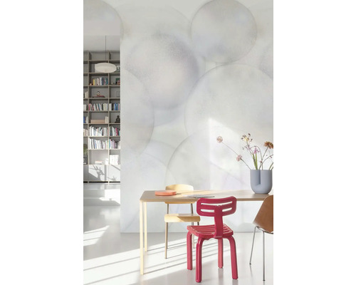 Světlá místnost s jídelním stolem, židlemi a tapetou s kruhovým vzorem