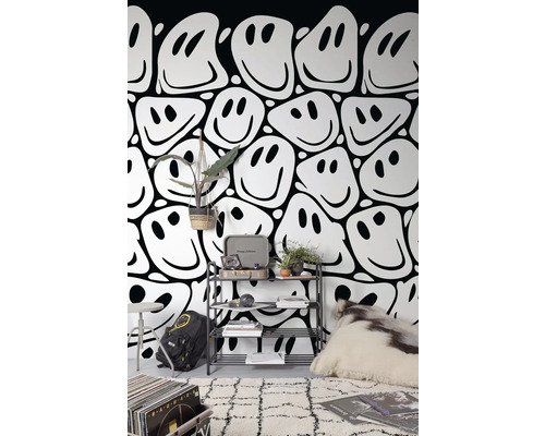 Obývací pokoj s tapetou se vzorem smajlíků, regálem, kobercem a dekorativními prvky