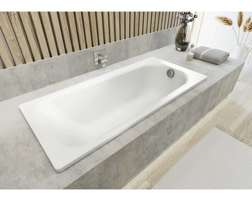 Bílá vana zabudovaná v koupelně s obkladovým lemem.