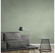 Obývací pokoj se zelenou textilní tapetou, pohovkou, lampou a stolem