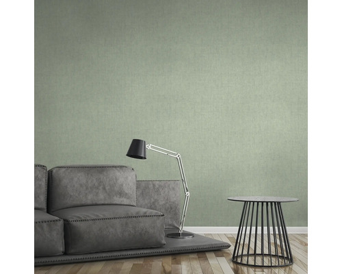 Obývací pokoj se zelenou textilní tapetou, pohovkou, lampou a stolem