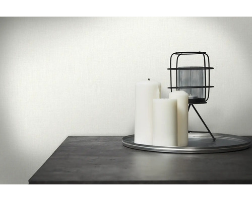 Dekorativní scéna s bílou textilní tapetou, svíčkami a lucernou