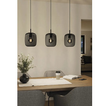 Tři kovová závěsná svítidla nad jídelním stolem.