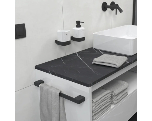 Moderní koupelna s umyvadlem, vodovodní baterií, dávkovačem mýdla, kelímkem na zubní kartáčky, ručníkem a držákem na ručníky.