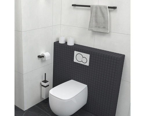 Moderní koupelna se závěsným WC, držákem na toaletní papír, WC štětkou a držákem na ručníky.